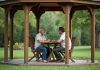 Couple assis sous un gazebo dans un jardin paisible