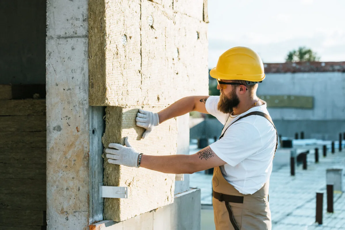 Travailleur en casque et lunettes sur un chantier d'isolation extérieure