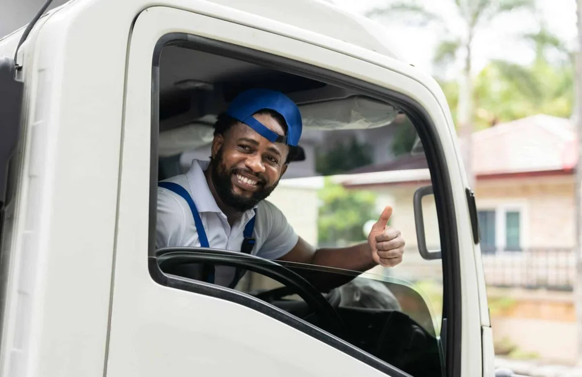 Chauffeur souriant préparant un camion de déménagement bleu